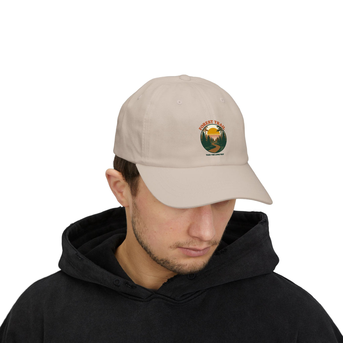 Man in a black hoodie wearing the Forest Trail dad cap in stone
